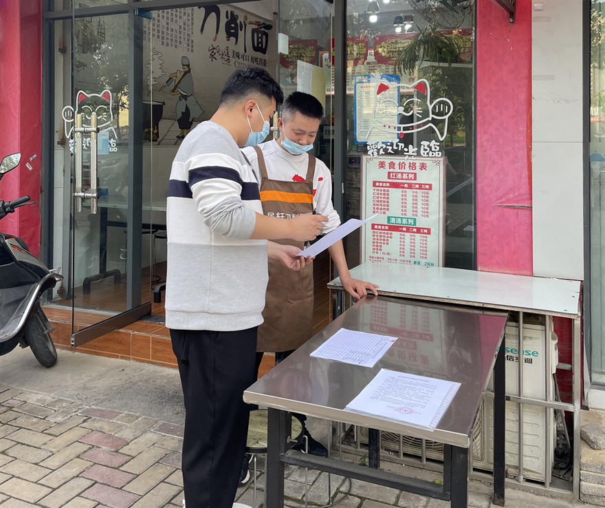 工作人(rén)員向商家宣傳和(hé / huò)發放疫情防控相關資料2_副本